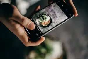 Blog Pessoa fotografando um prato de comida com o celular