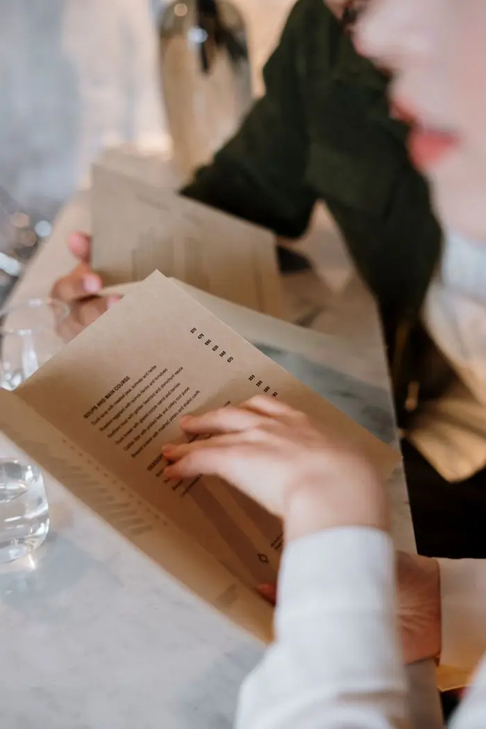 A couple explores menu options in a cozy restaurant setting, reflecting elegance and intimacy.